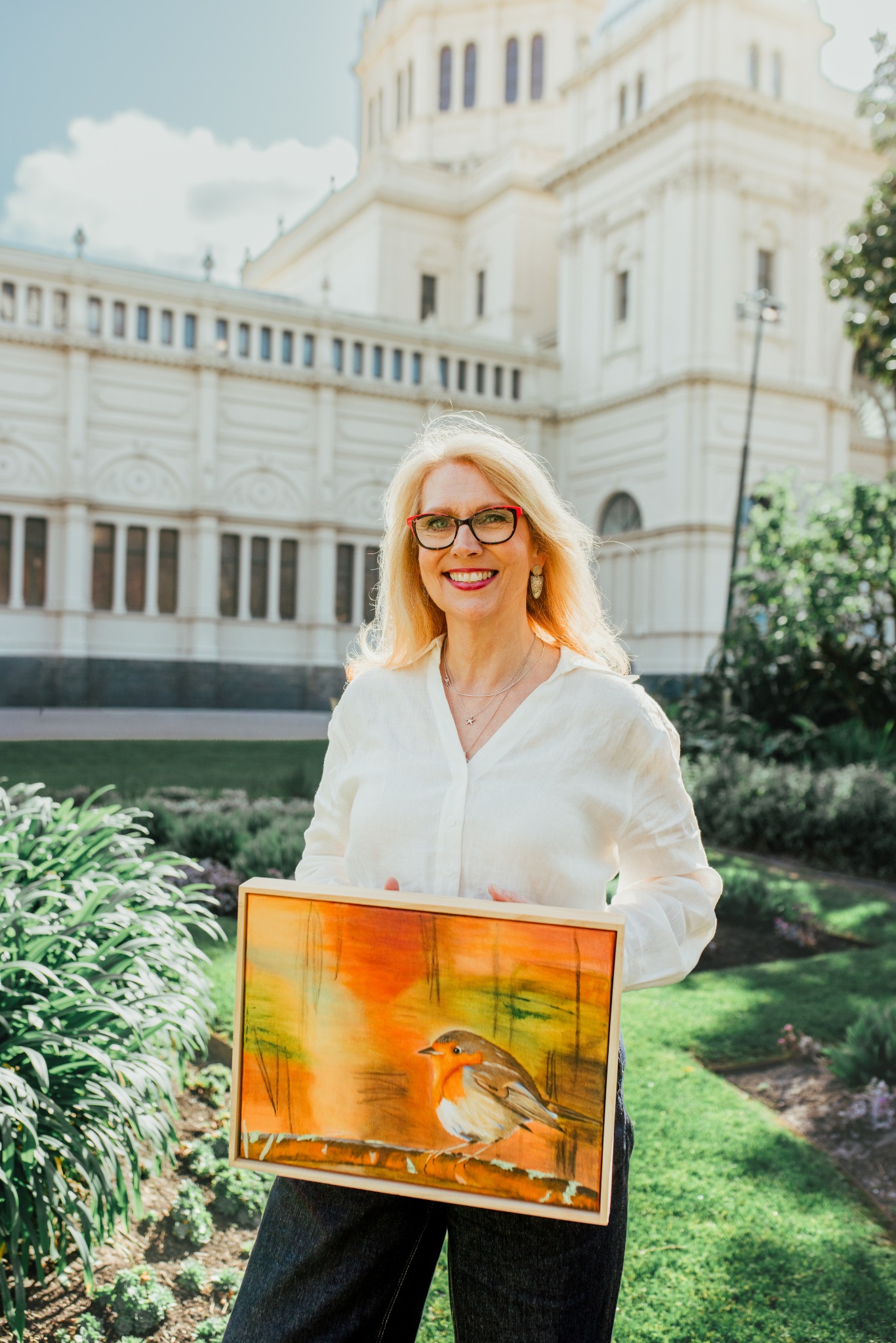 Artist Kimberley holding a bird painting