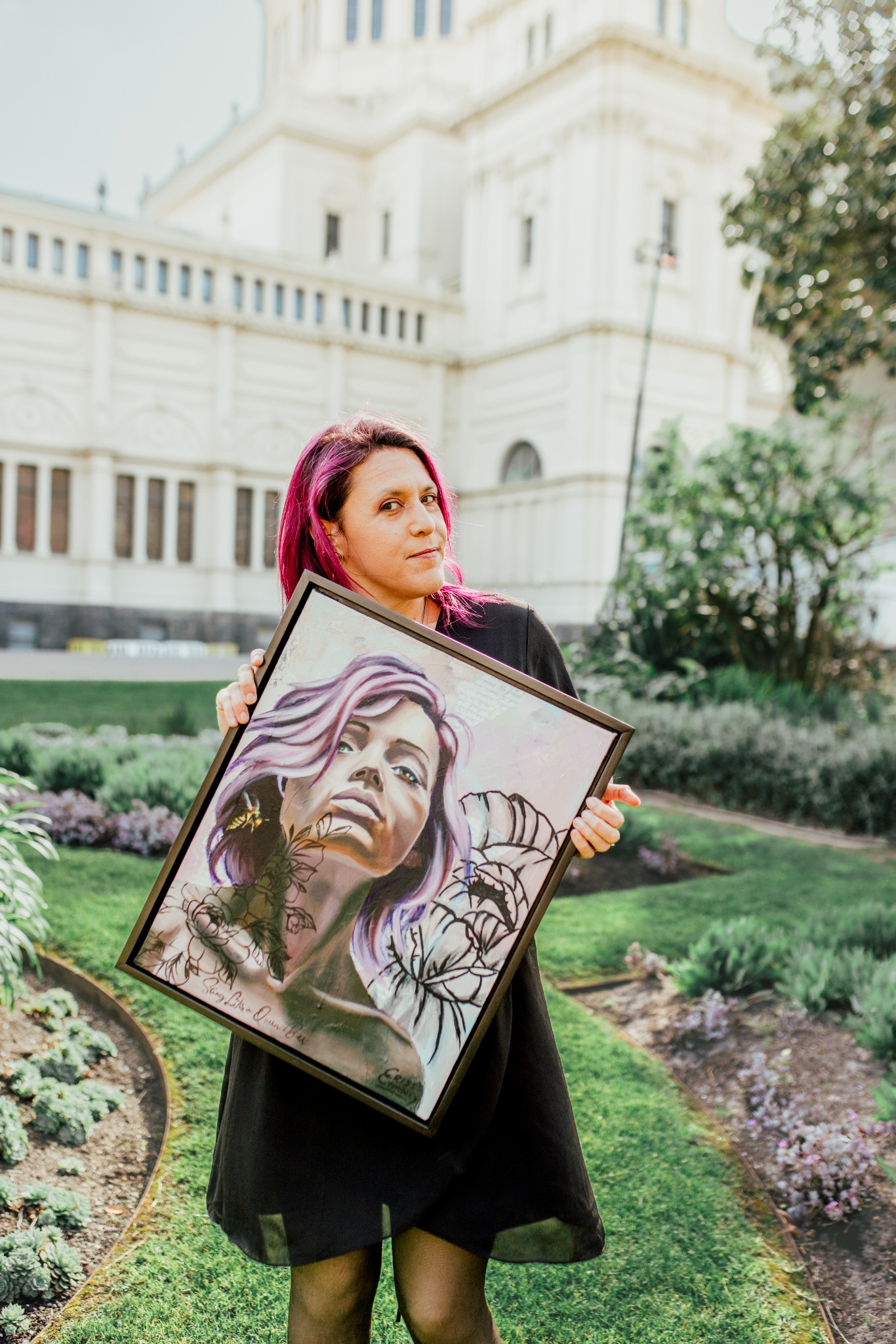 Artist Criss holding one of her paintings